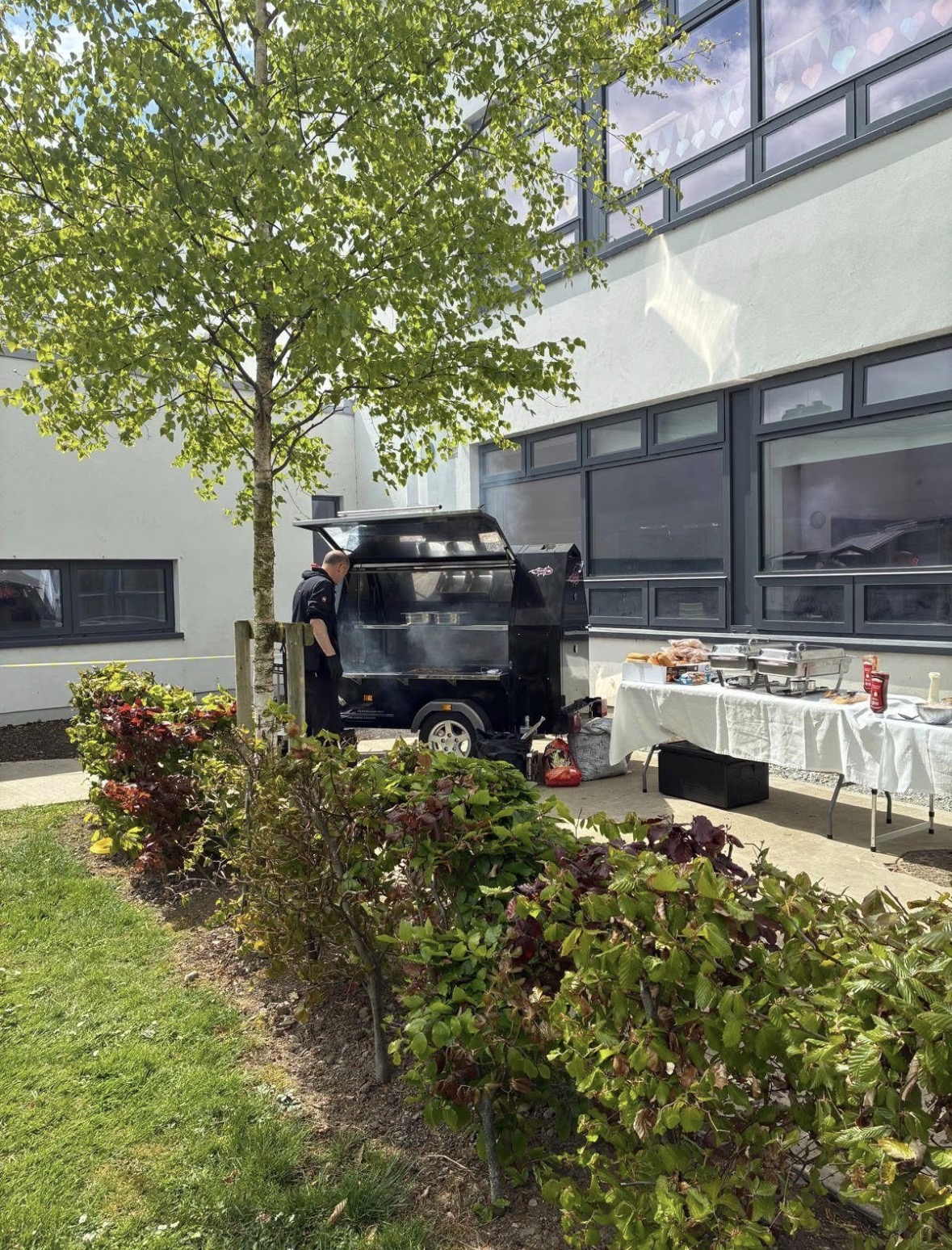 Corporate event catering setup with BBQ trailer and buffet