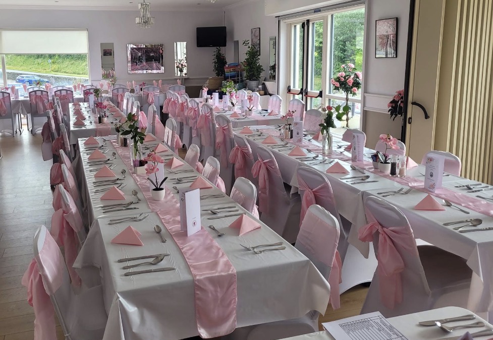 Elegant private party dining room set with pink napkins and chair sashes