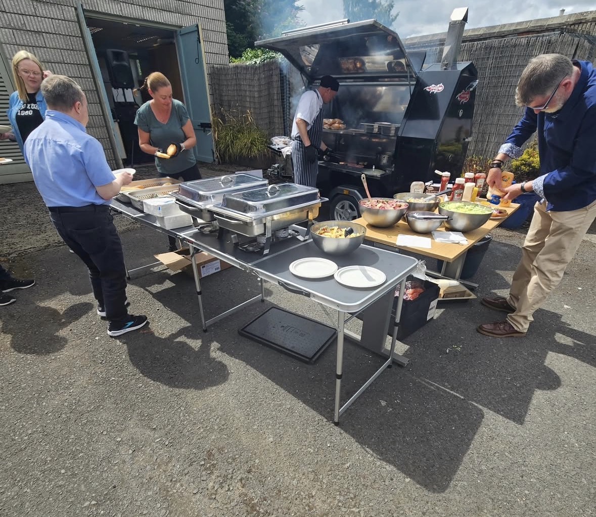 Guests being served at an outdoor wedding buffet